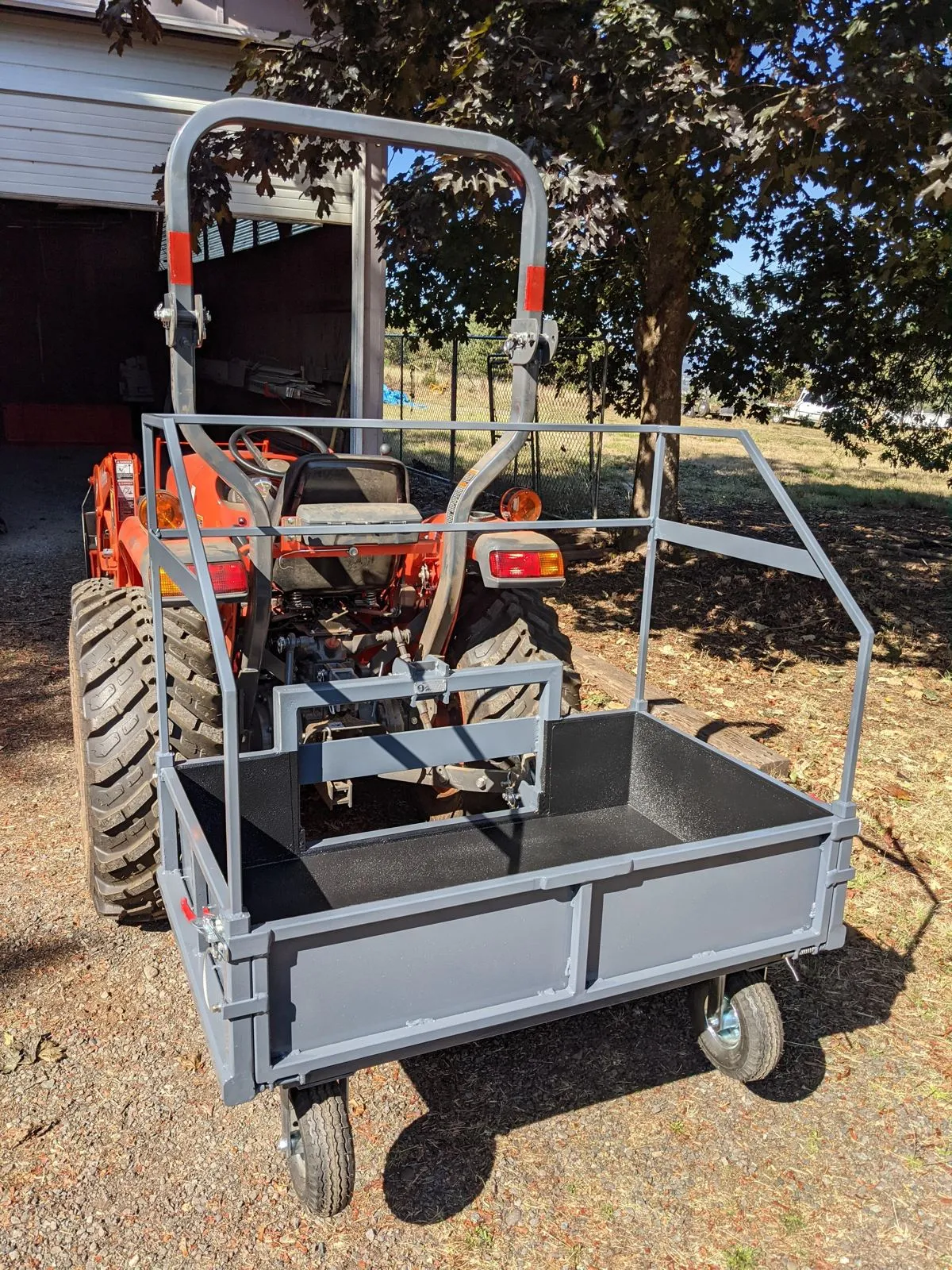 The finished carry-all mounted on the tractor, with the top frame and tailgate fitted
