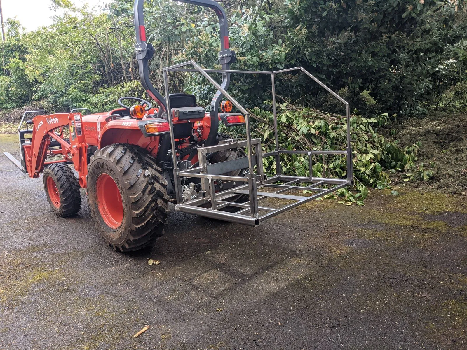 The carry-all hauling a load of brush behind the tractor