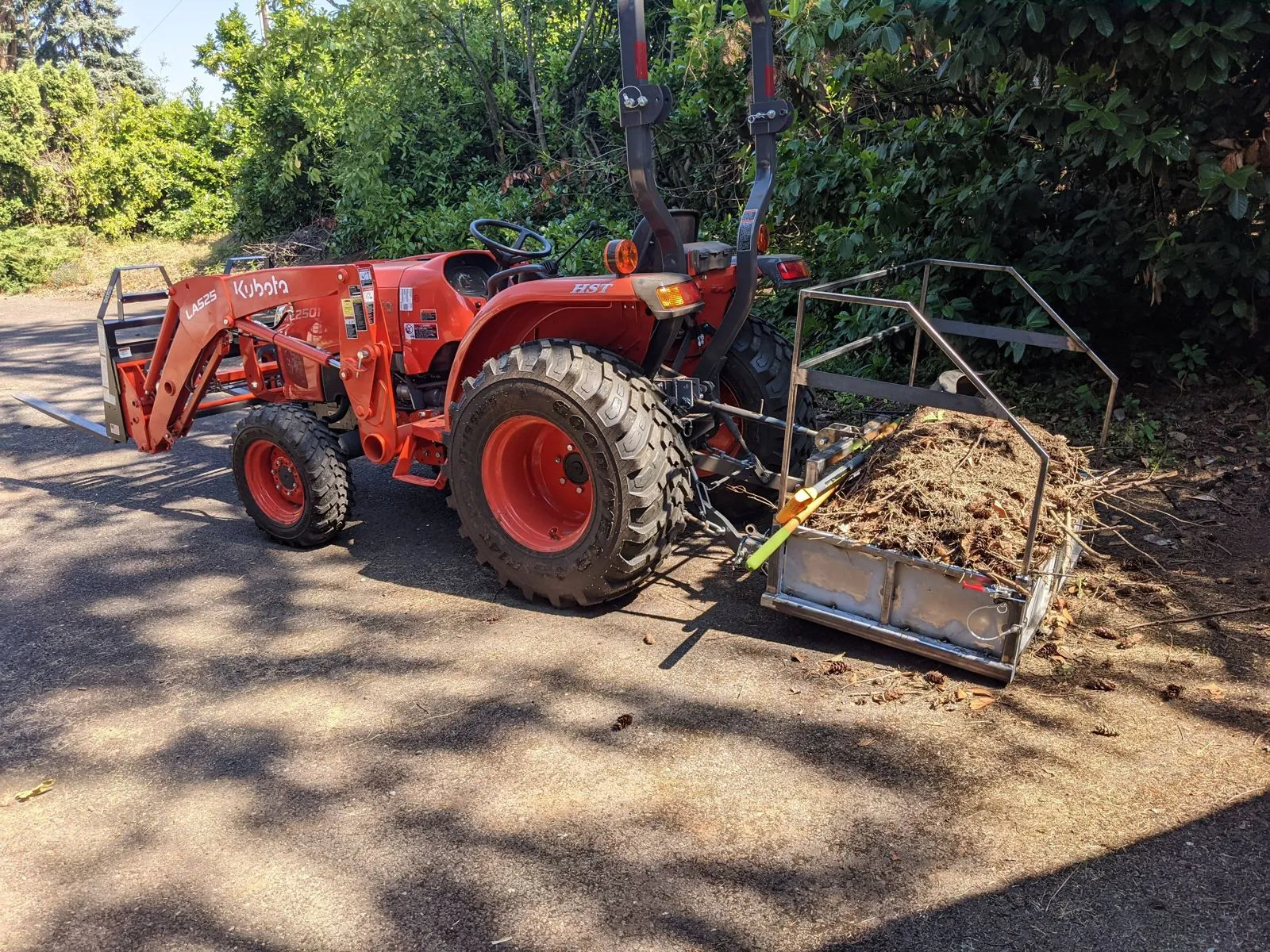 The carry-all loaded with debris on the back of the tractor