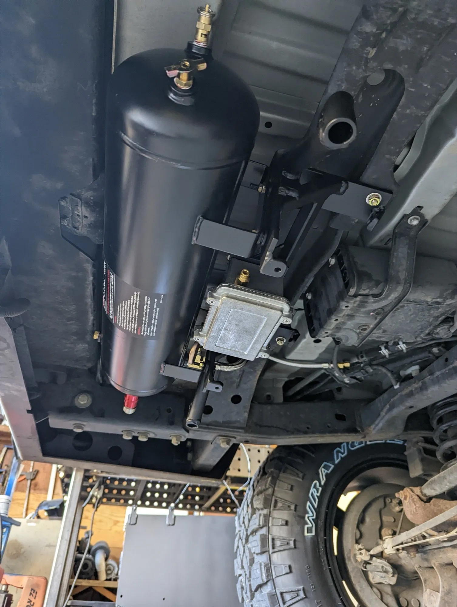 Onboard air tank in the spare tire well, on its fabricated mount next to the solenoid enclosure