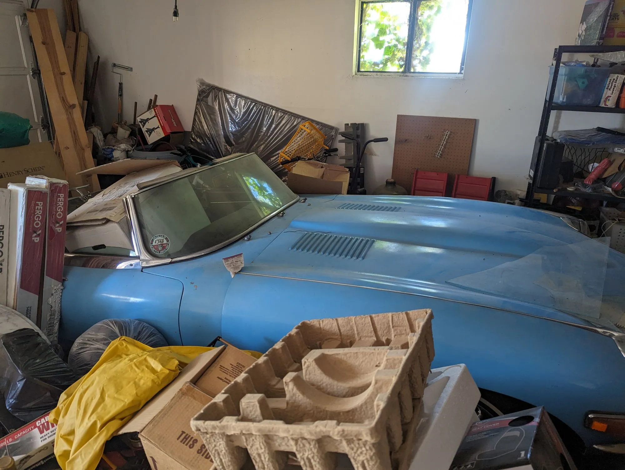 The E-Type as found, buried in a crowded garage