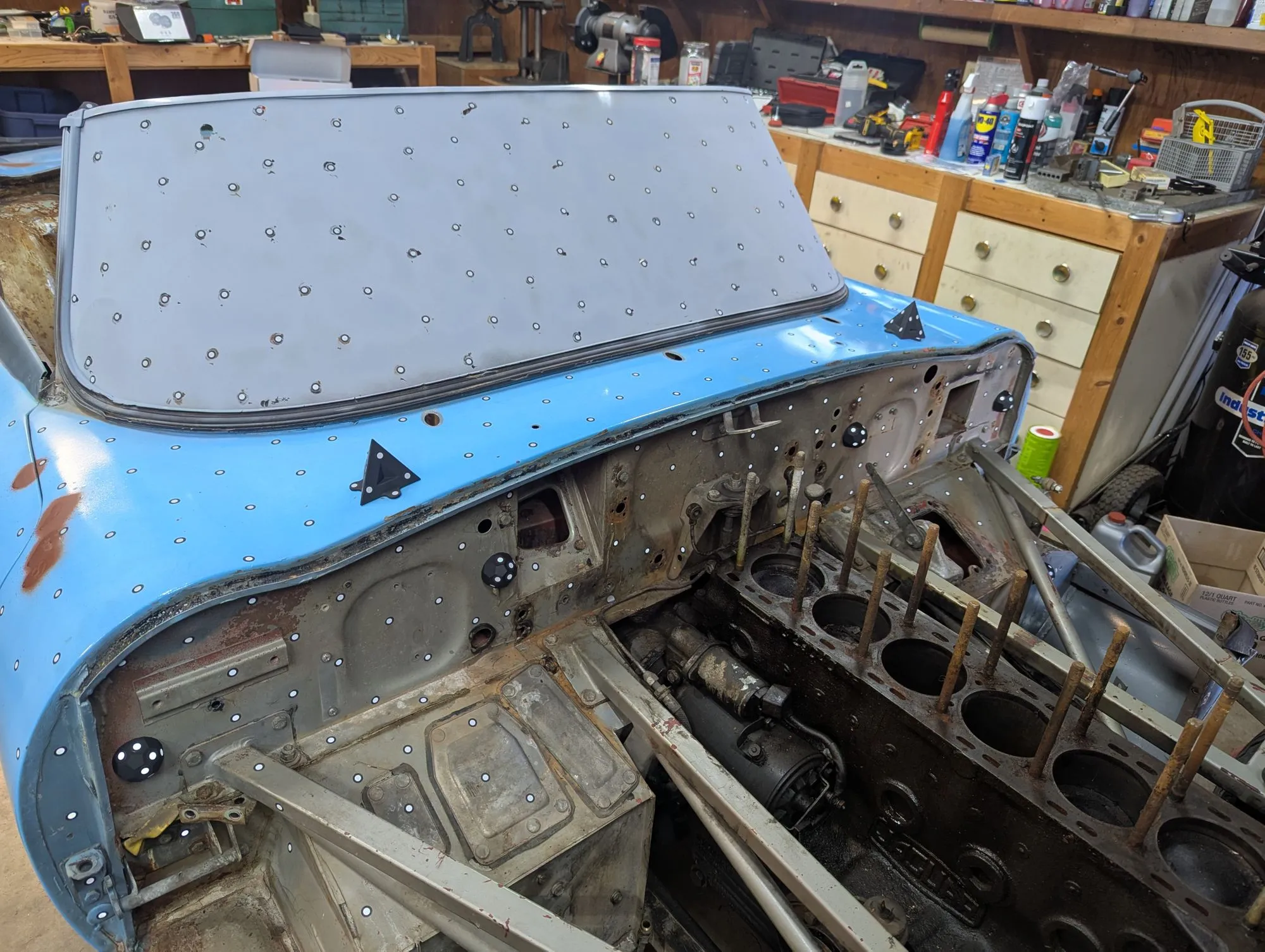 The stripped E-Type engine bay and firewall, mid-teardown