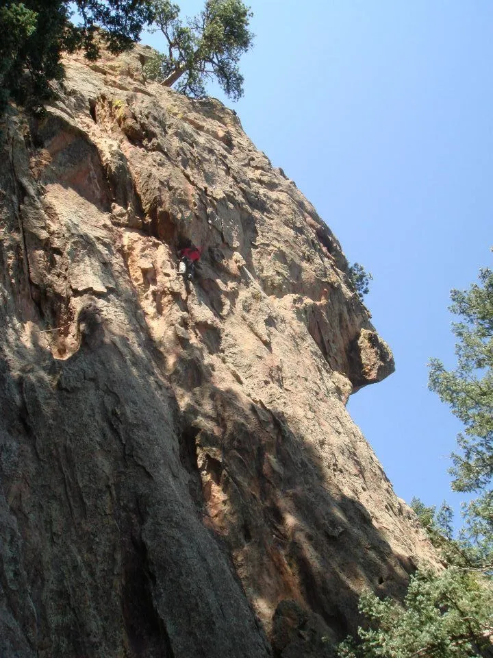 James on a tall rock face against a blue sky