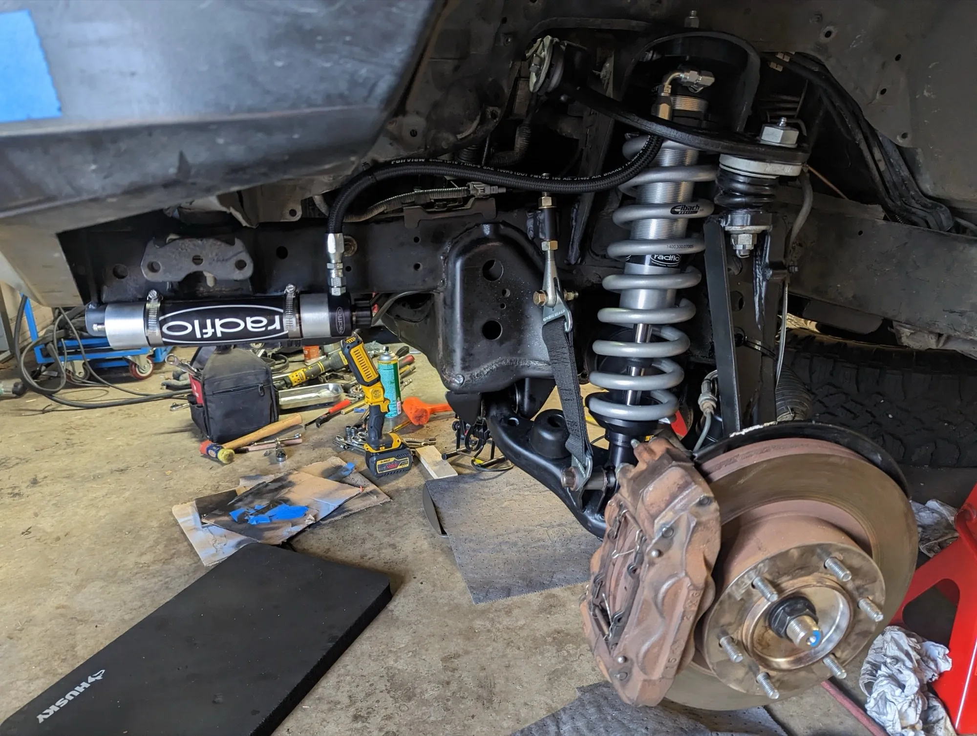 Front suspension on the lift: Radflo coilover and remote reservoir, SPC upper control arm, and gusseted lower arm